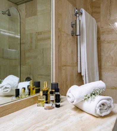 Elegant bathroom with towels, luxury products, and flowers.