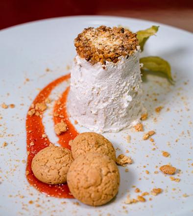 Semifreddo with hazelnut crumble and amaretti on fruit sauce.