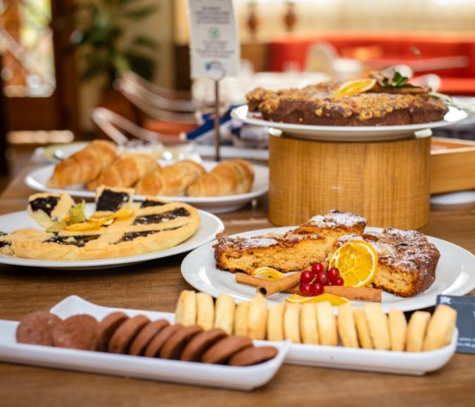 Dessert buffet with cakes, cookies, and croissants.