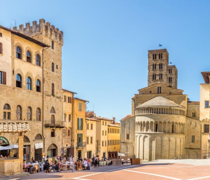 Historic square with medieval architecture and outdoor cafes.