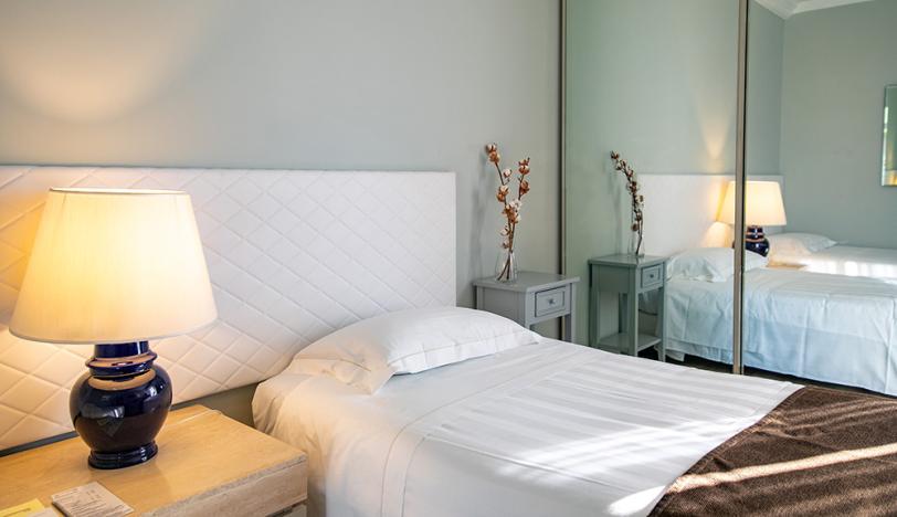 Camera da letto moderna con specchio, lampada e decorazioni semplici.