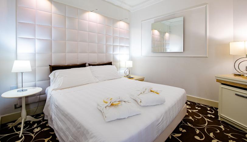 Elegant room with a double bed, soft lighting, and modern furnishings.