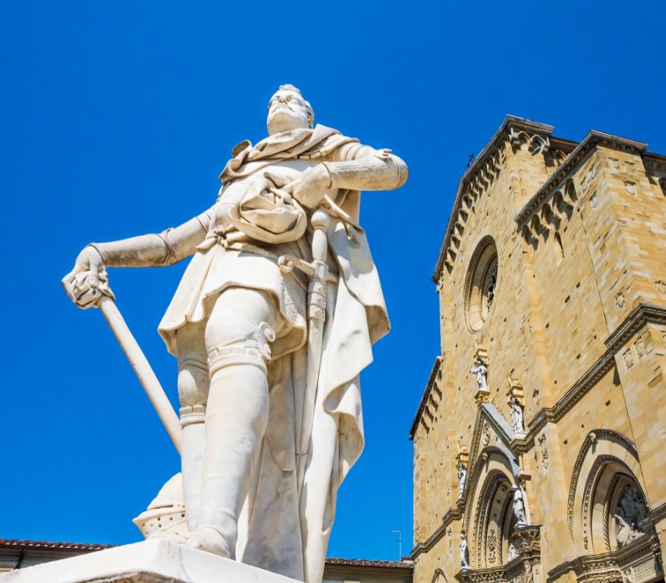 Statue of a warrior in front of a historic church.